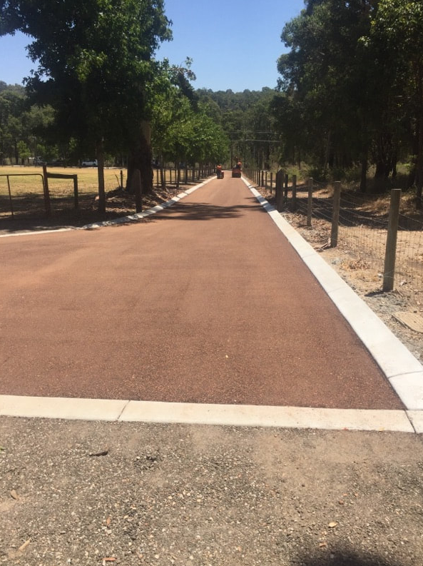This is a photo of a hot spray & seal bitumen roadway which is in the process of being installed by Young Road Tek